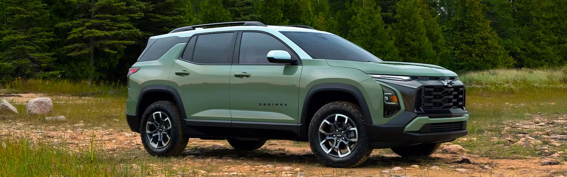 Green Chevrolet Equinox on a forest trail.