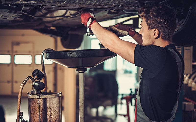 Chevy Certified Service Technician performing oil change
