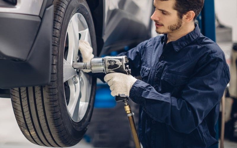 mechanic putting tire on a car